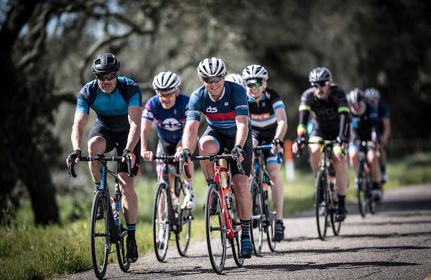 cyclists ride side by side